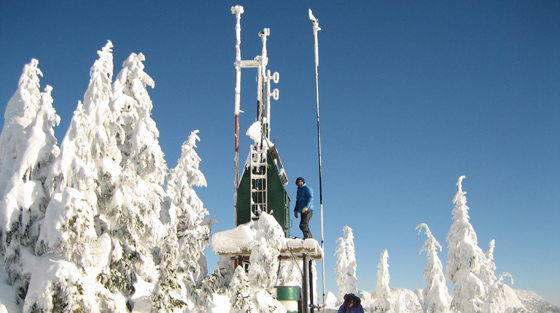 Avalanche technician standing on Great Bear weather station, Coquihalla, BC